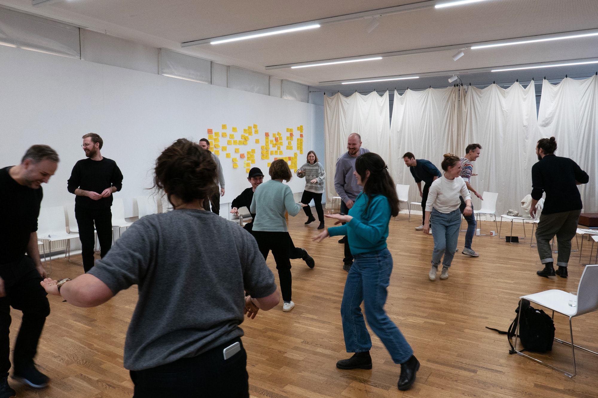 Participants doing a movement exercise together in a bright workshop room asphalt kollektiv