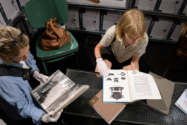 Zwei Personen mit weißen Handschuhen blättern in einem Fotoalbum und einem Katalog mit Geschirrentwürfen asphalt kollektiv