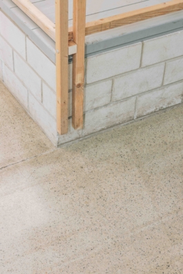 Detail: Ecke des Holzgerüsts auf einem Sockel aus Betonsteinen asphalt kollektiv